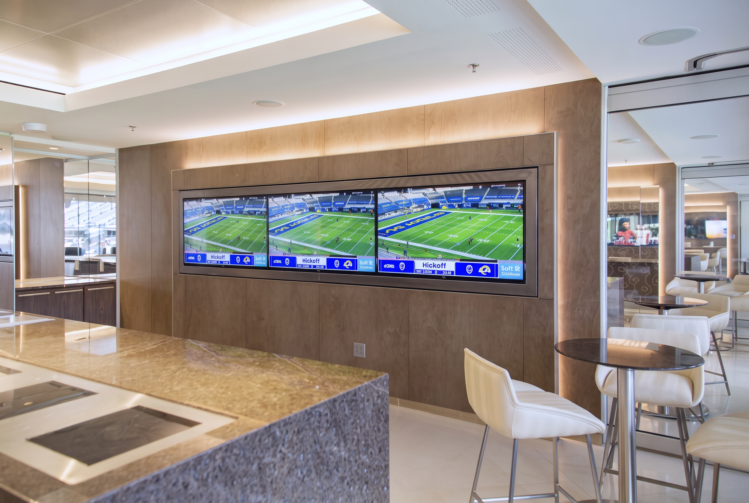 VIP suite lounge with multi-screen viewing wall and cocktail seating