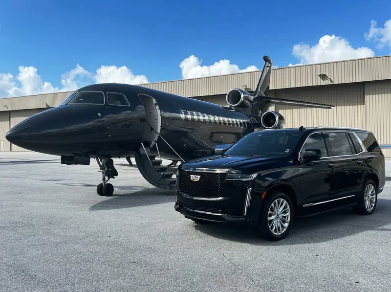 Black Cadillac Escalade beside a private jet for Los Angeles FBO chauffeur service